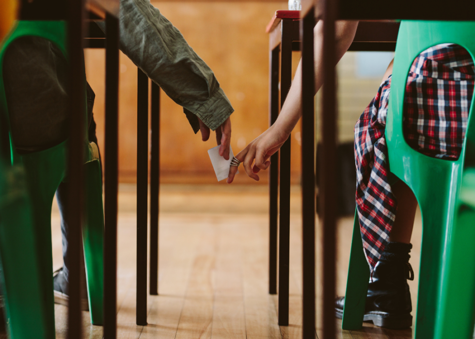 Two students passing a note during class