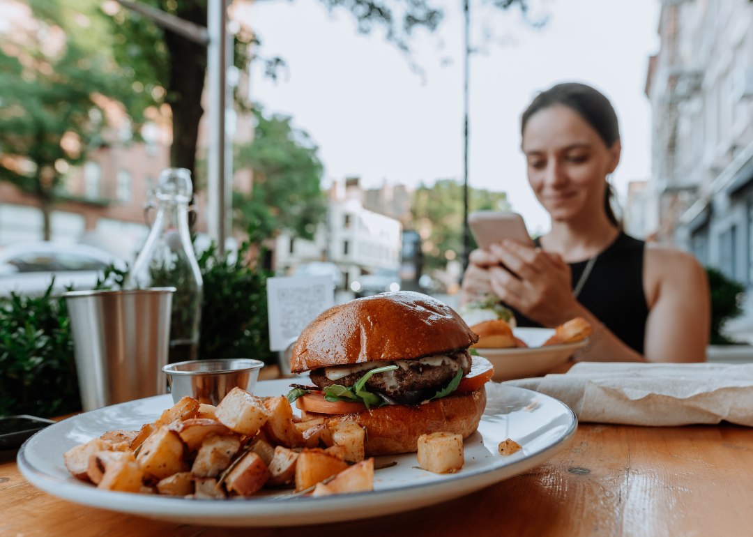 Plate with vegan burger in outdoor cafe.
