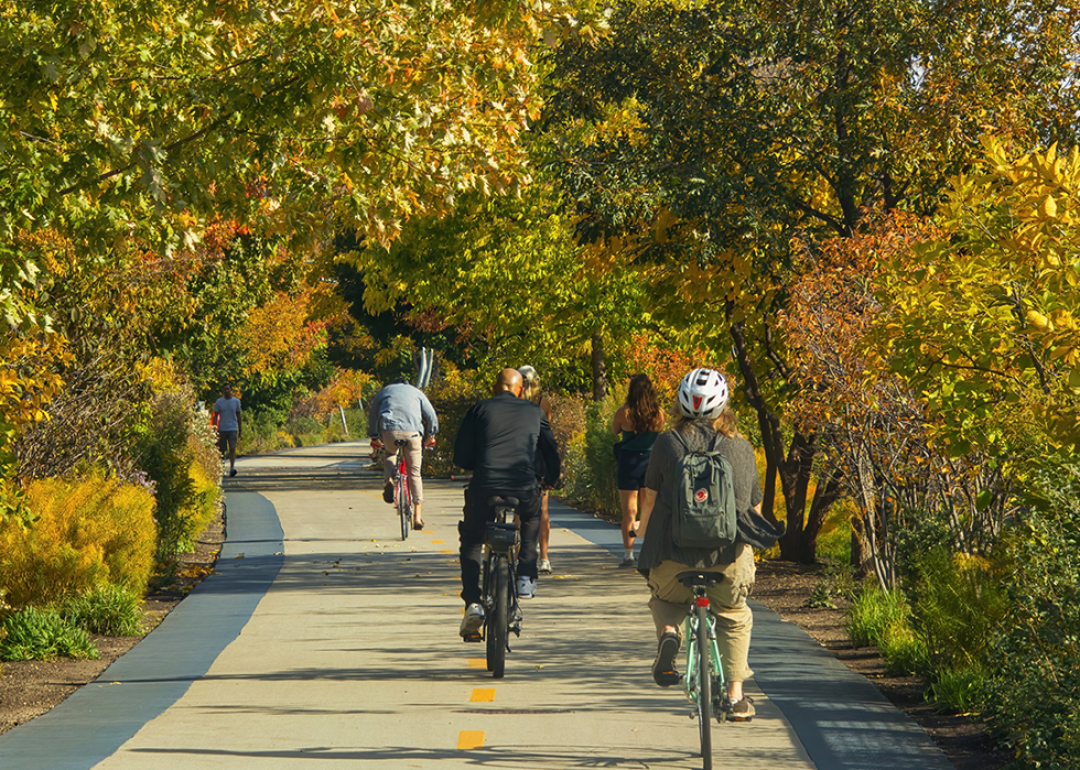 Cyclists peddling through a grove of colorful trees on the Bloomingdale Trail.