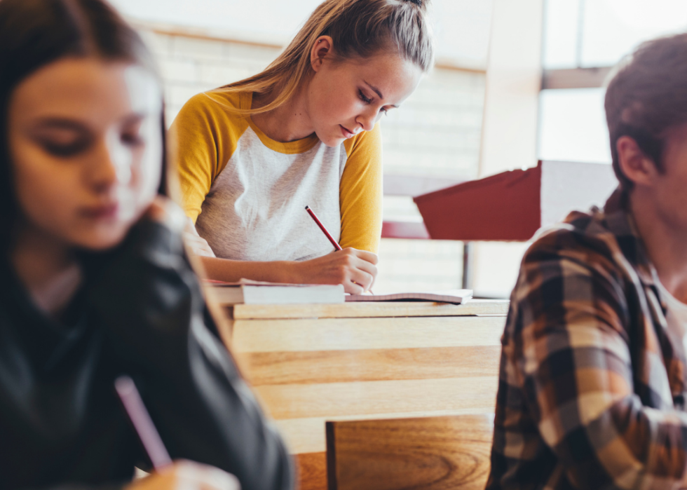Three seated teen students in classroom