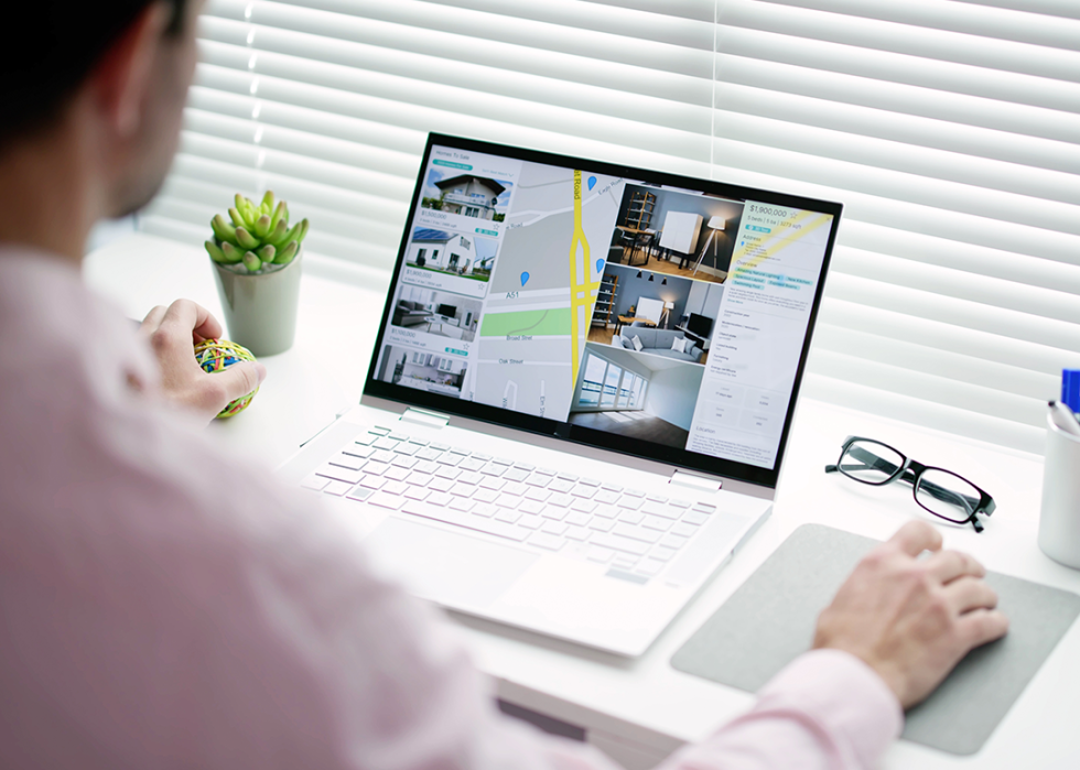 Realtor reviewing listings on laptop.