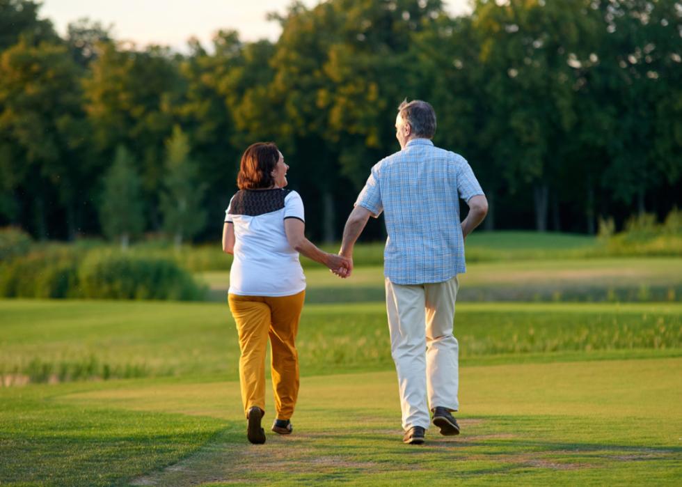 Couple walking on lawn in summer.