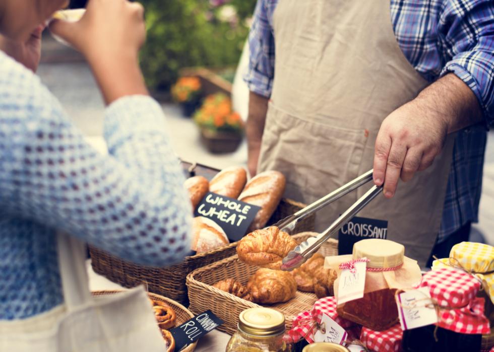 Vendor at food market serving customer