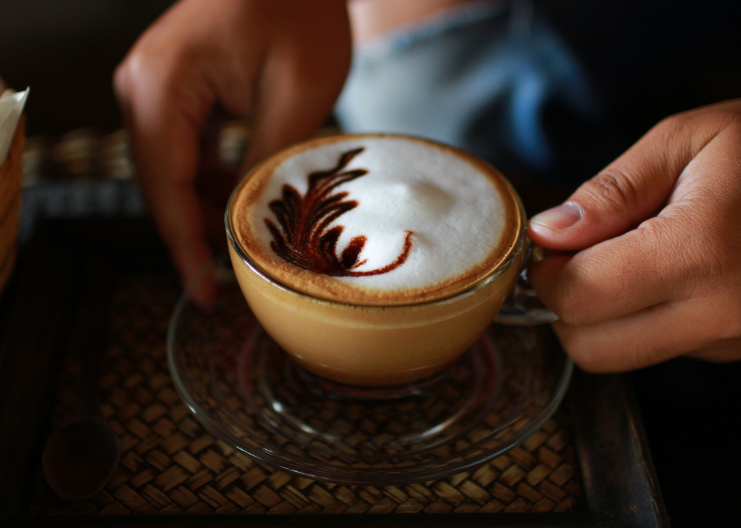Person holding cup with freshly prepared drink.