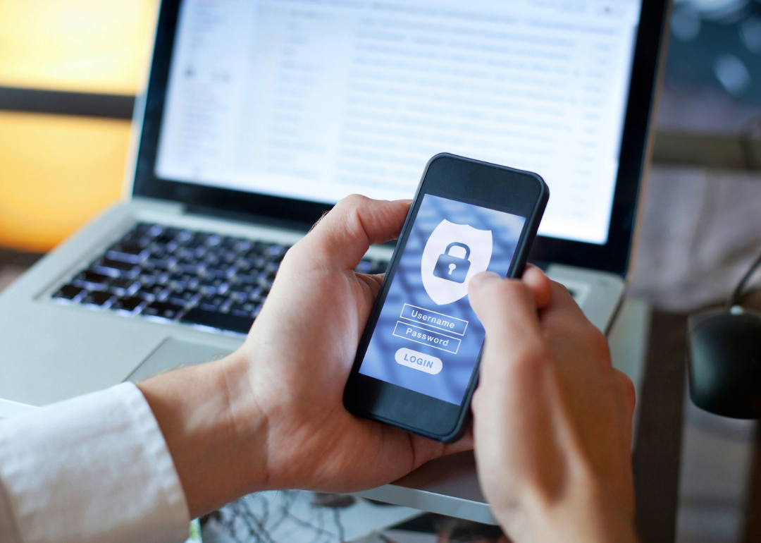 Hand holding phone with security login.
