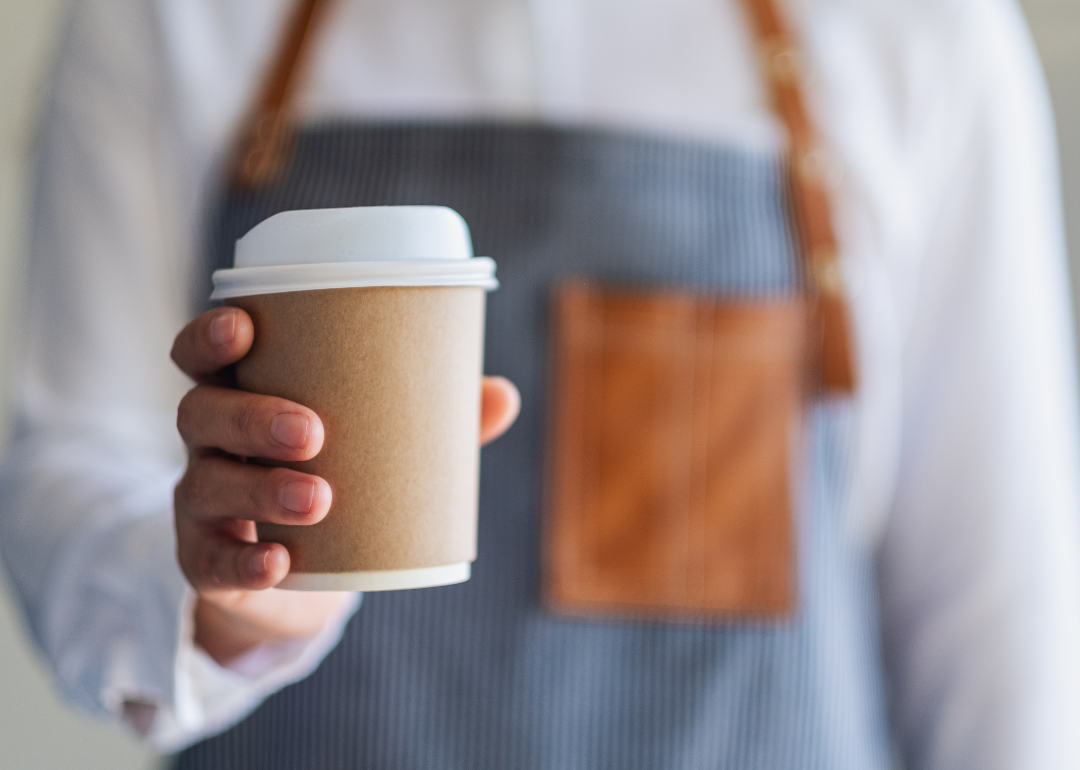 Barista holding cup of coffee.