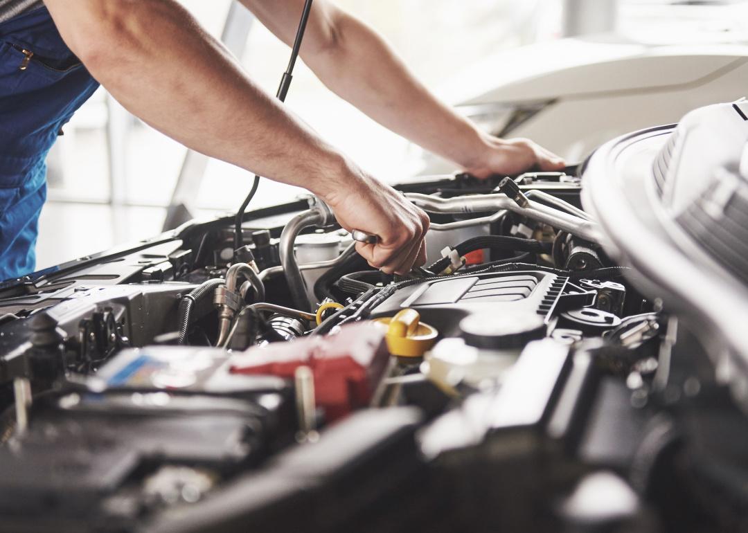 Mechanic working on car engine.