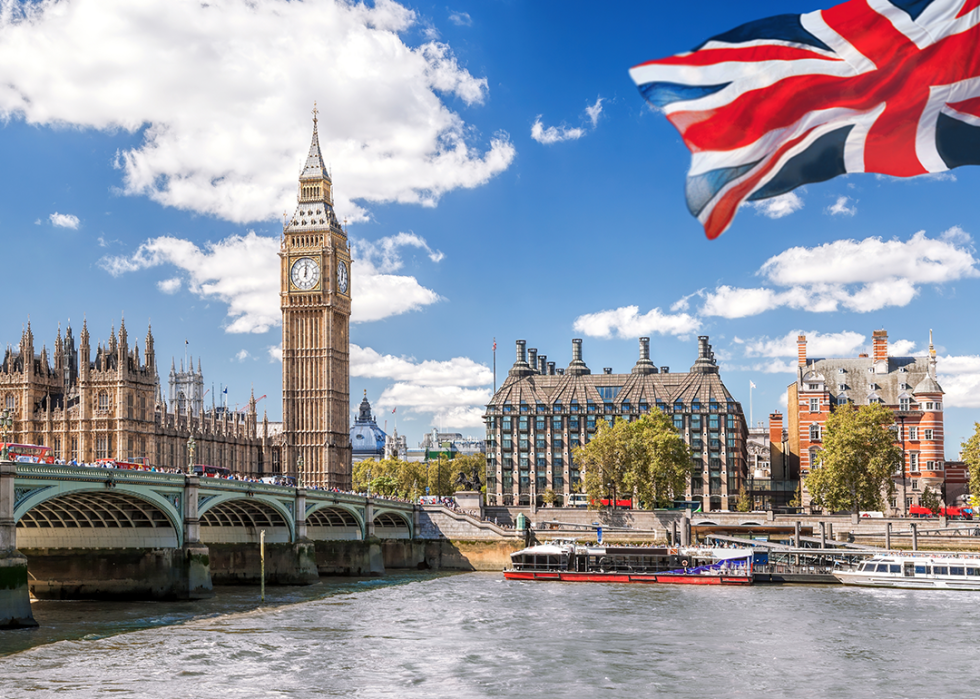 Big Ben with the bridge over Thames and a flag of England.