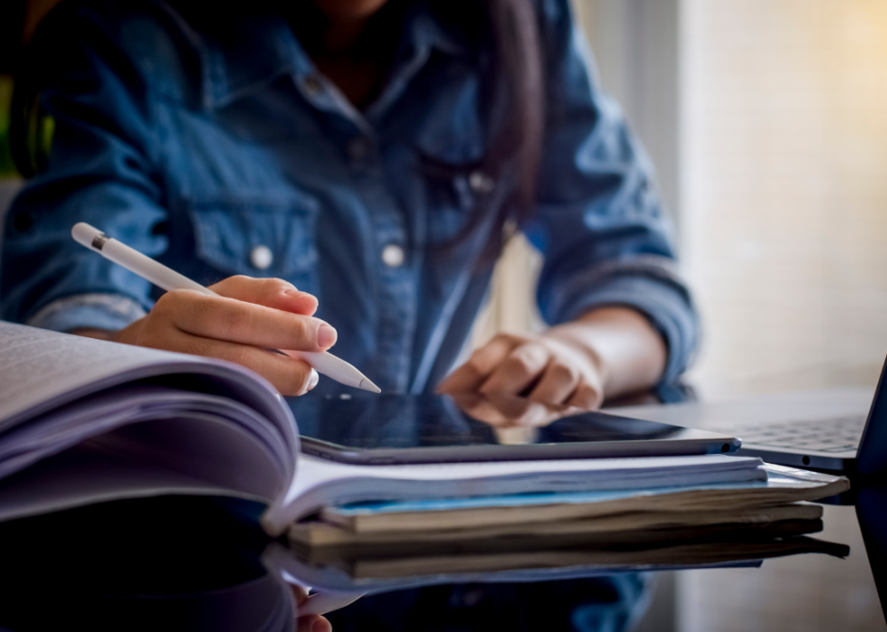 Female student with tablet and pen at desk