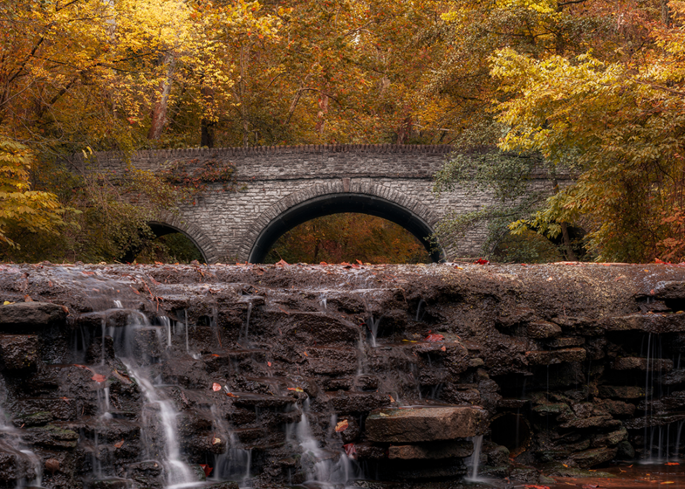 A waterfall near a stone arched bridge in Sharon Woods Park