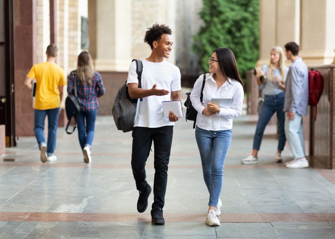 Two university students walking together on a college campus.