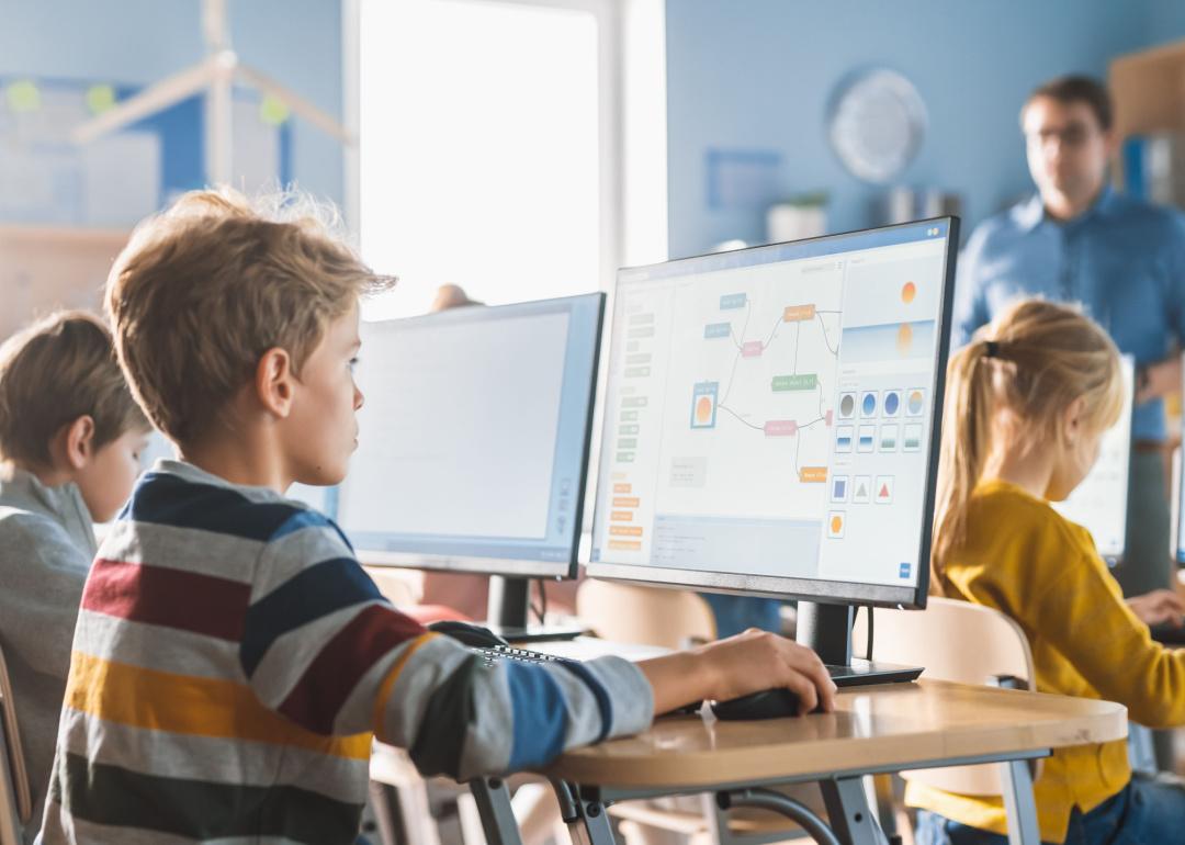 School children at desk in computer lab.