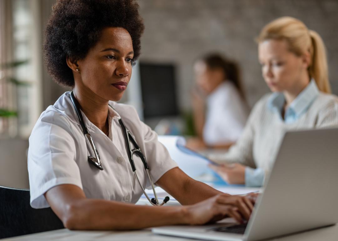 Doctor typing on a laptop.