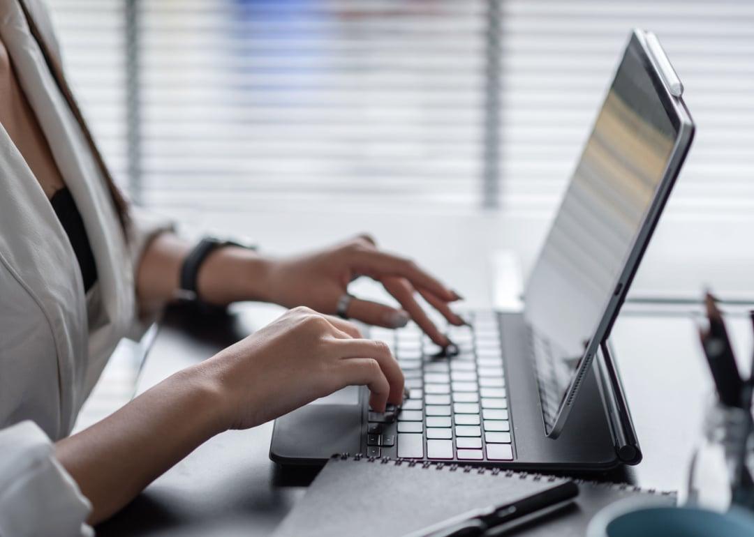Woman typing on tablet keyboard in office.