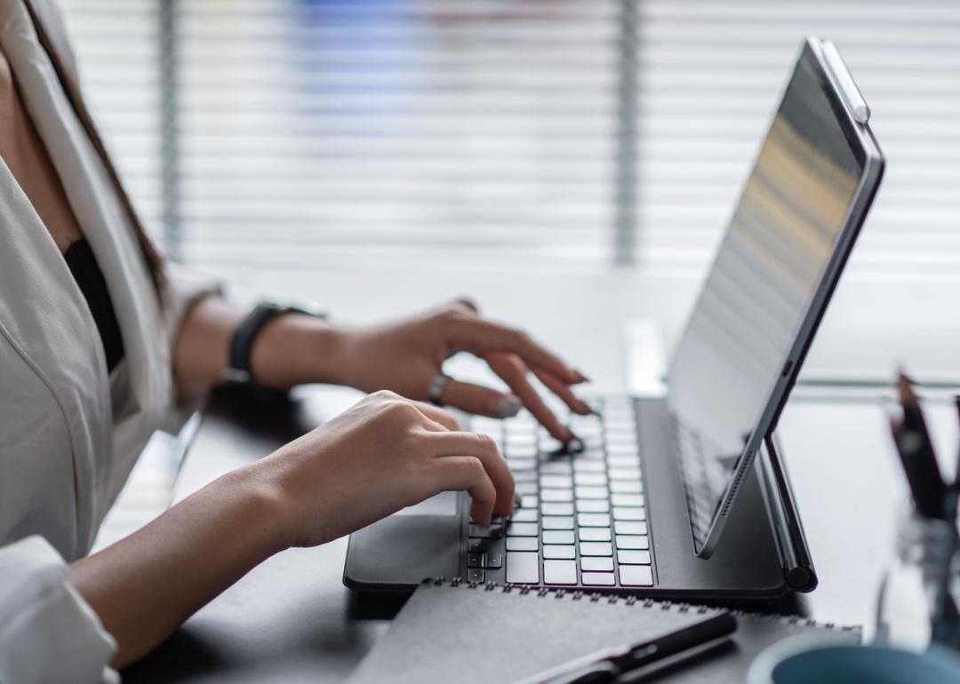 Person typing on tablet keyboard in office.