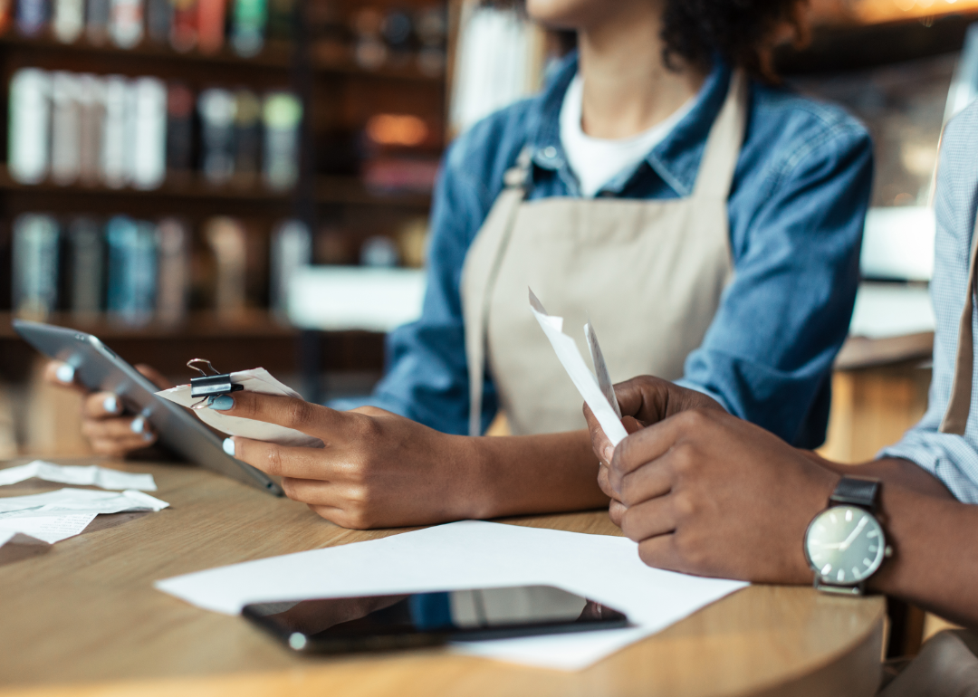 Small business owner and bookkeeper managing records.