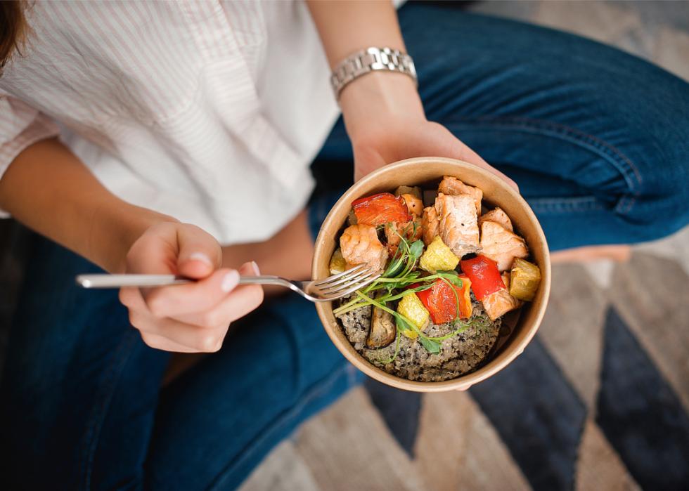 Woman eating bowl of healthy food