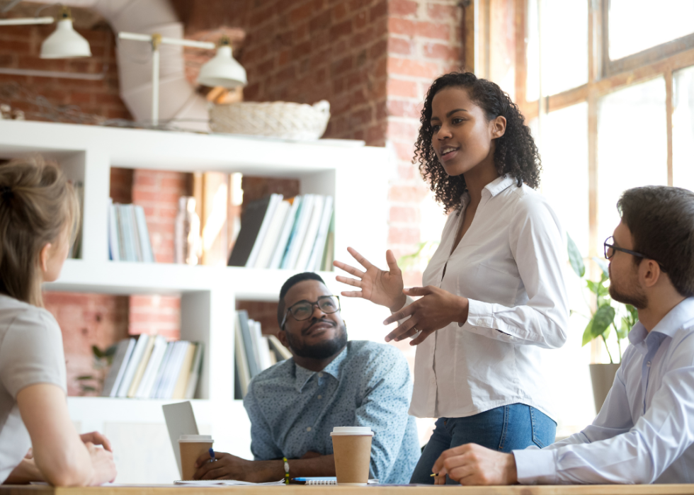 Black woman leading diverse team meeting