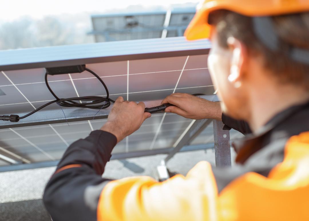 Electrician connecting wires of solar panels.