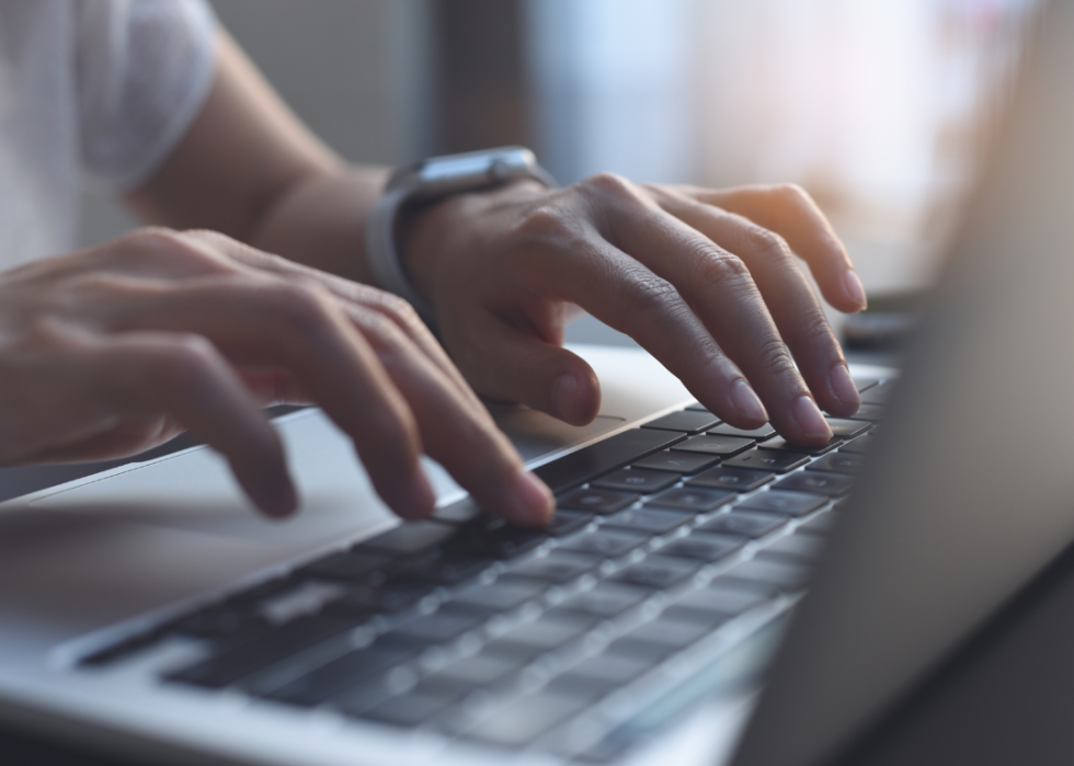 Hands typing on laptop computer keyboard