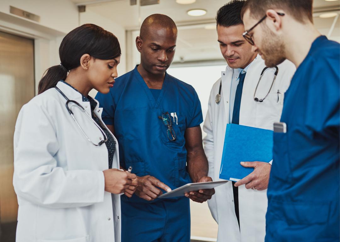 Medical team conferring with tablet.