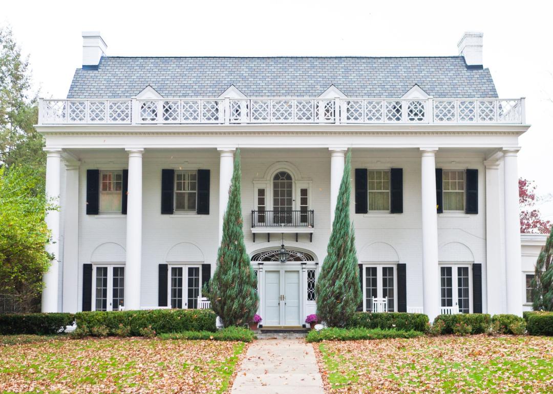 Exterior Neoclassical mansion with white columns and black shutters.