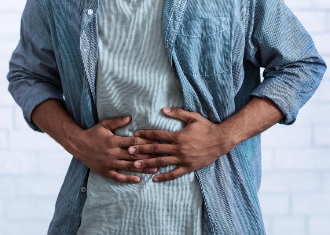 Cropped view of man holding stomach.