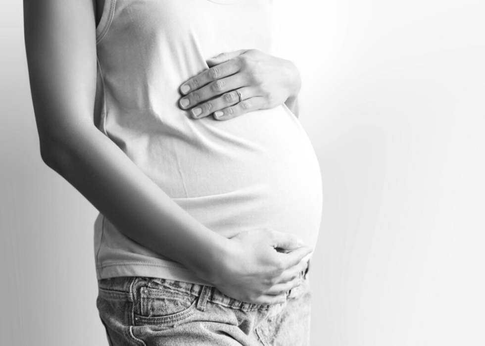 Pregnant person holds their baby bump