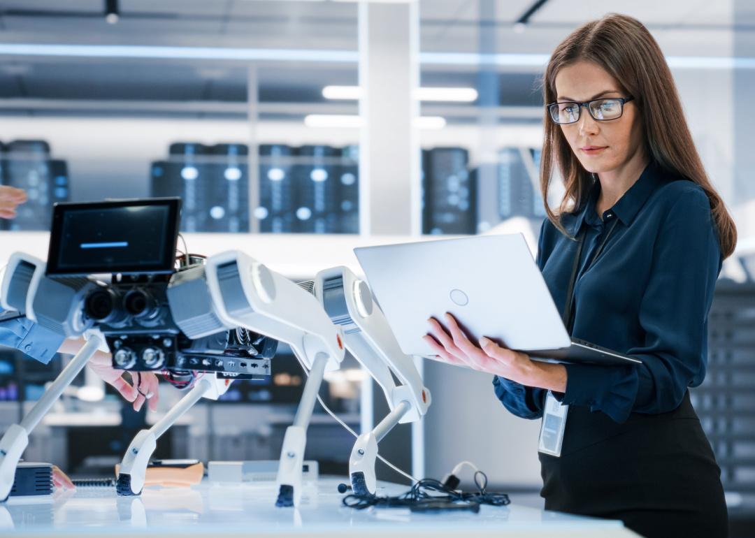 Robotics engineer analyzing mobile robot.