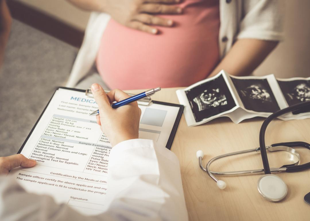 Pregnant woman with ultrasound visiting obstetrician.