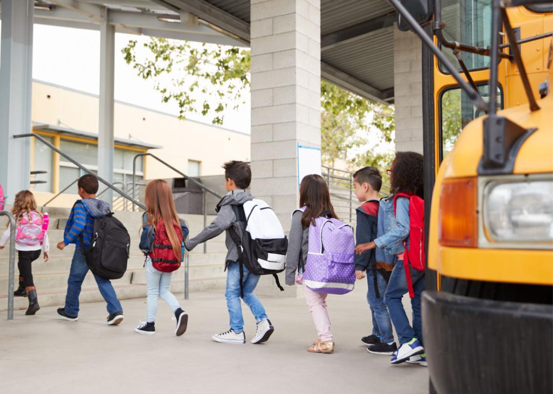 Elementary school students walking into school building.