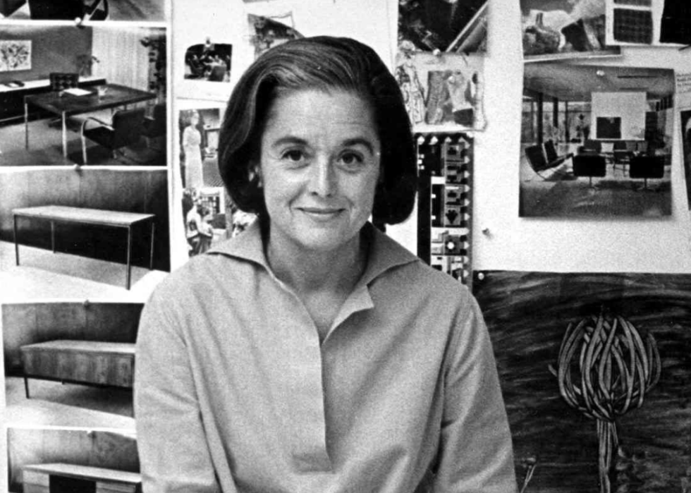 Florence Knoll Bassett as she sits on the edge of a table with a book of fabric swatches.