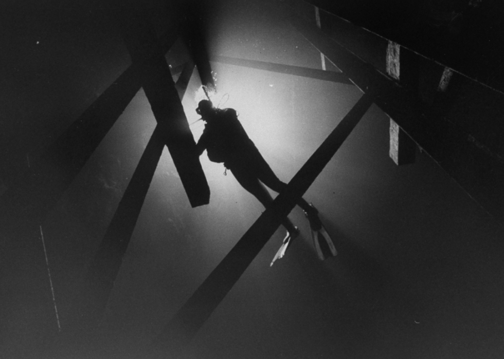 A scuba diver with a light exploring the Bonne Terre mine.