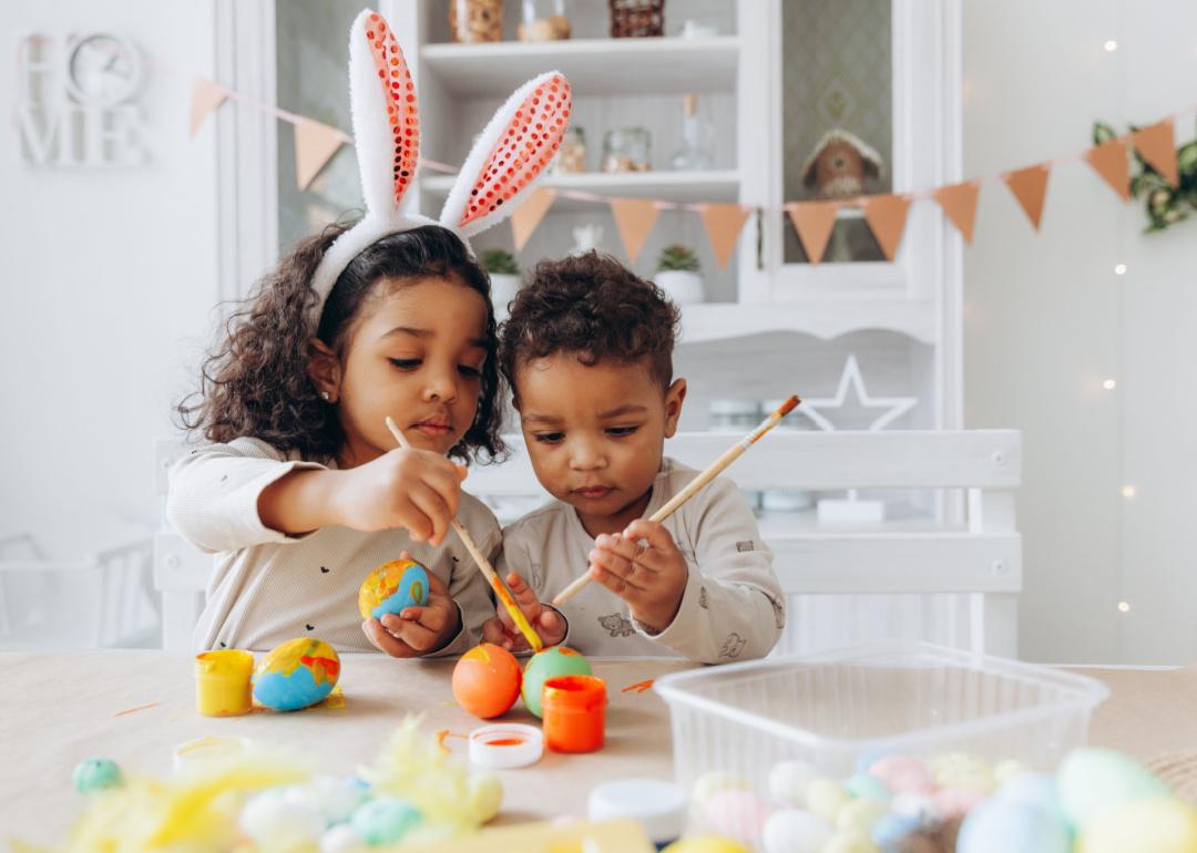 Children paint Easter eggs.