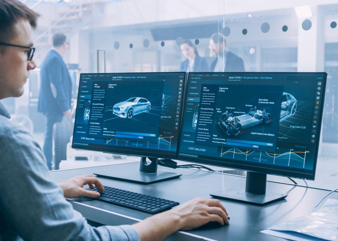 Person working on computer in automotive design office.