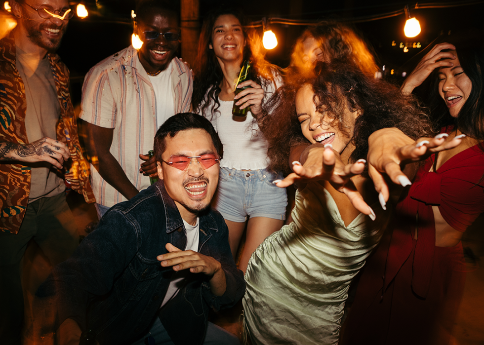 Friends dancing at a roof club party.