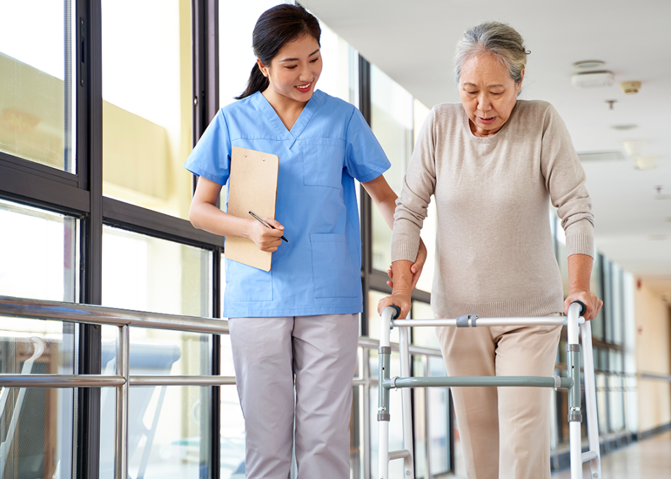 Therapist works with woman using walker.