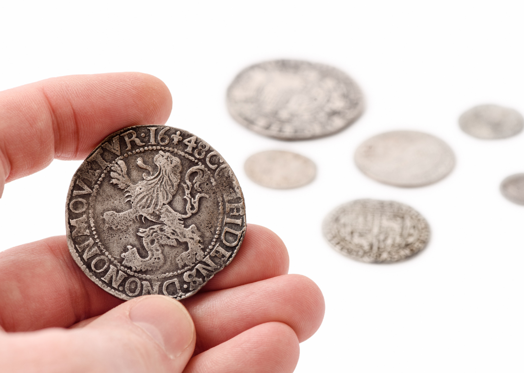 Hand holding silver thaler.