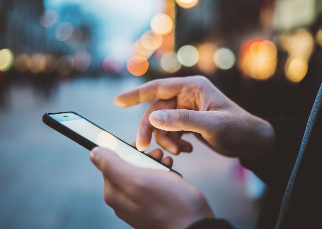 Hands using smartphone at night