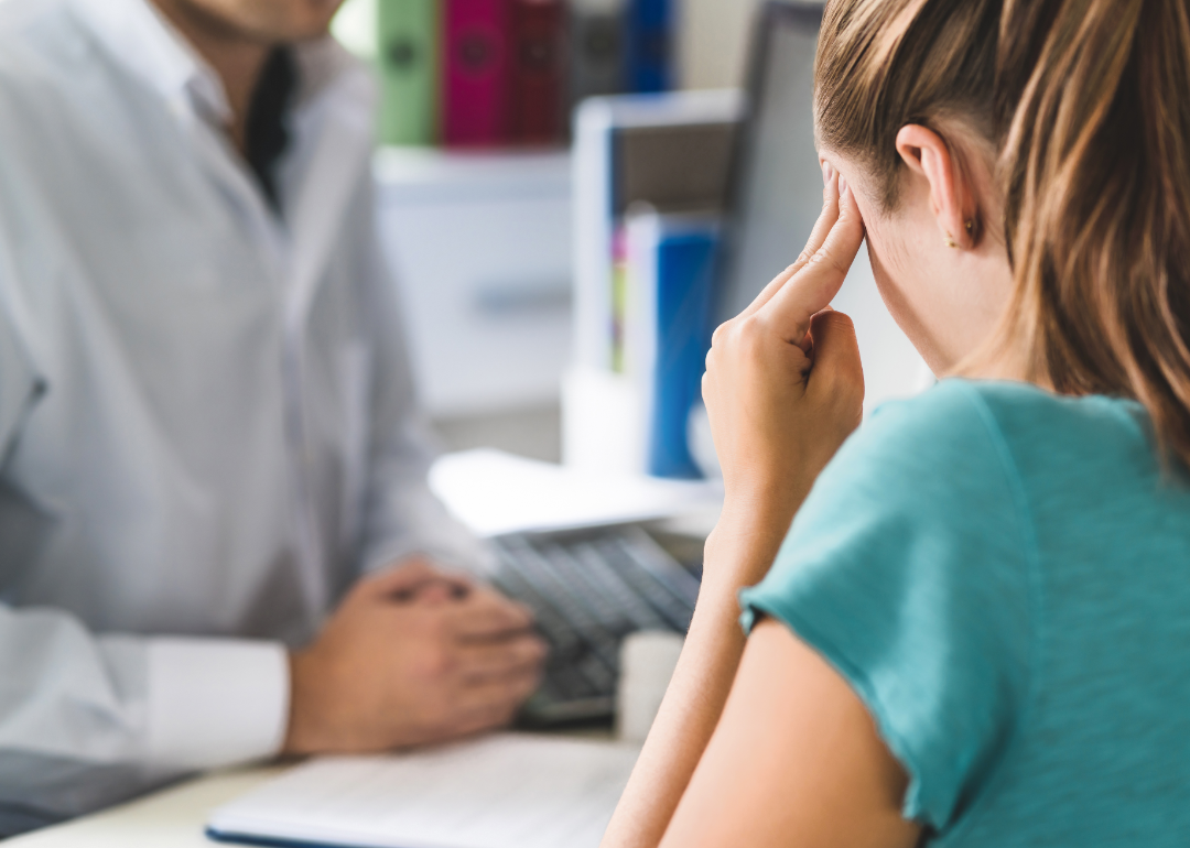 Woman describing headache to doctor.