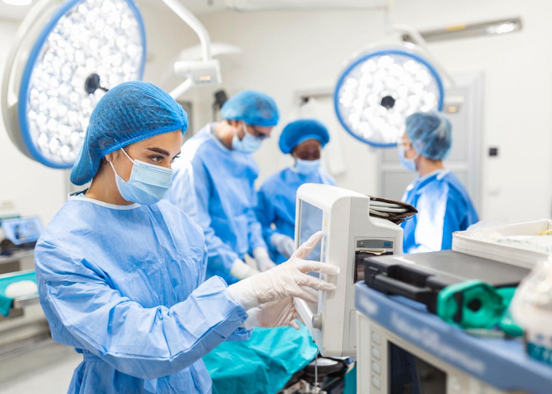 Anesthetist assistant tracking vital functions during surgery.