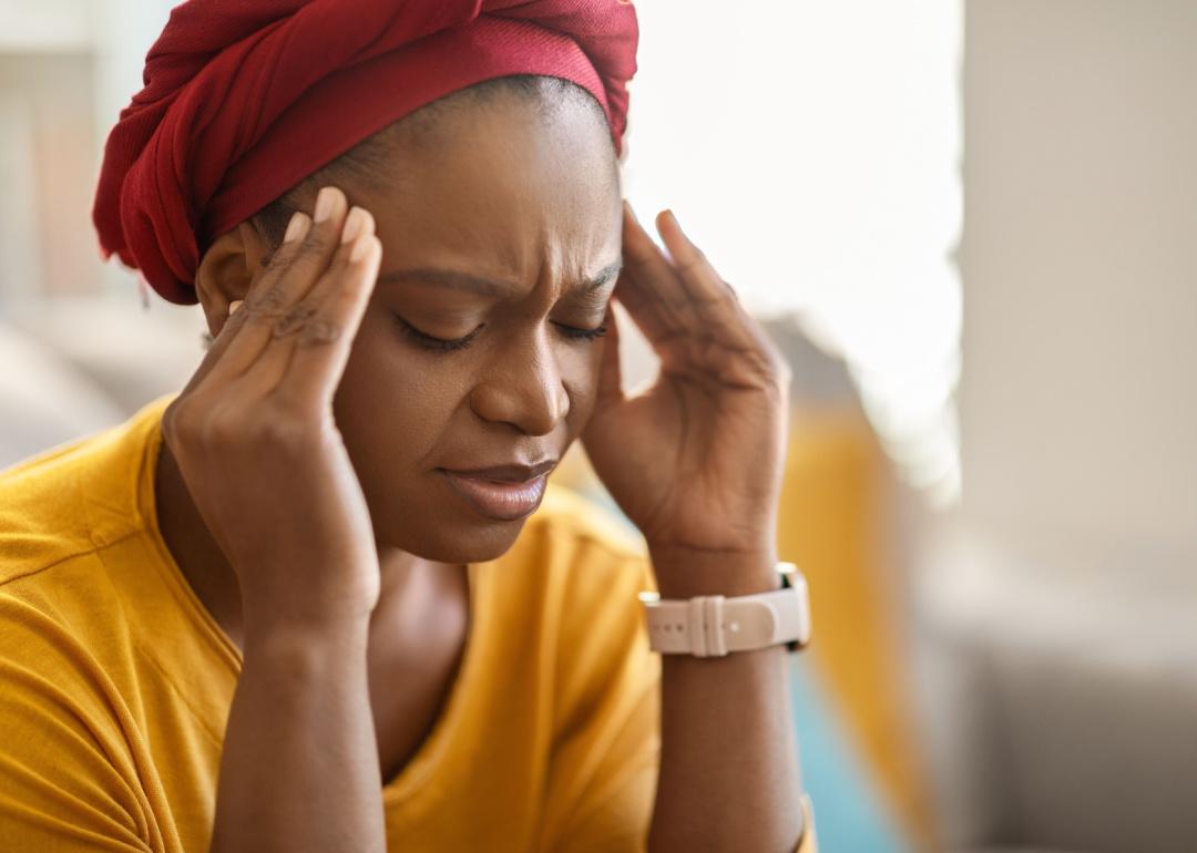 Woman holding head in pain.