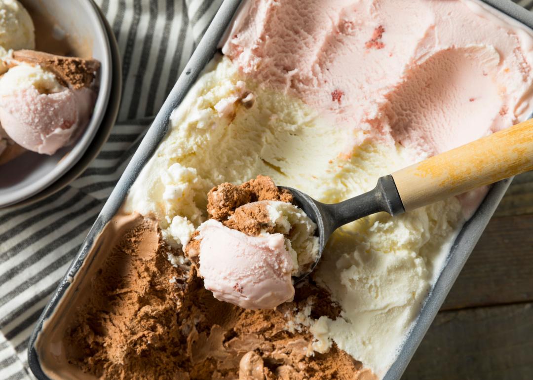 Scoop in container of Neapolitan ice cream.