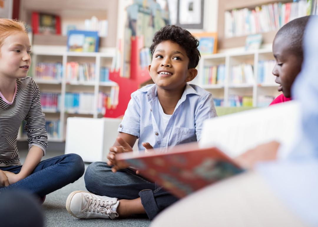 Group of elementary students sitting together in library.
