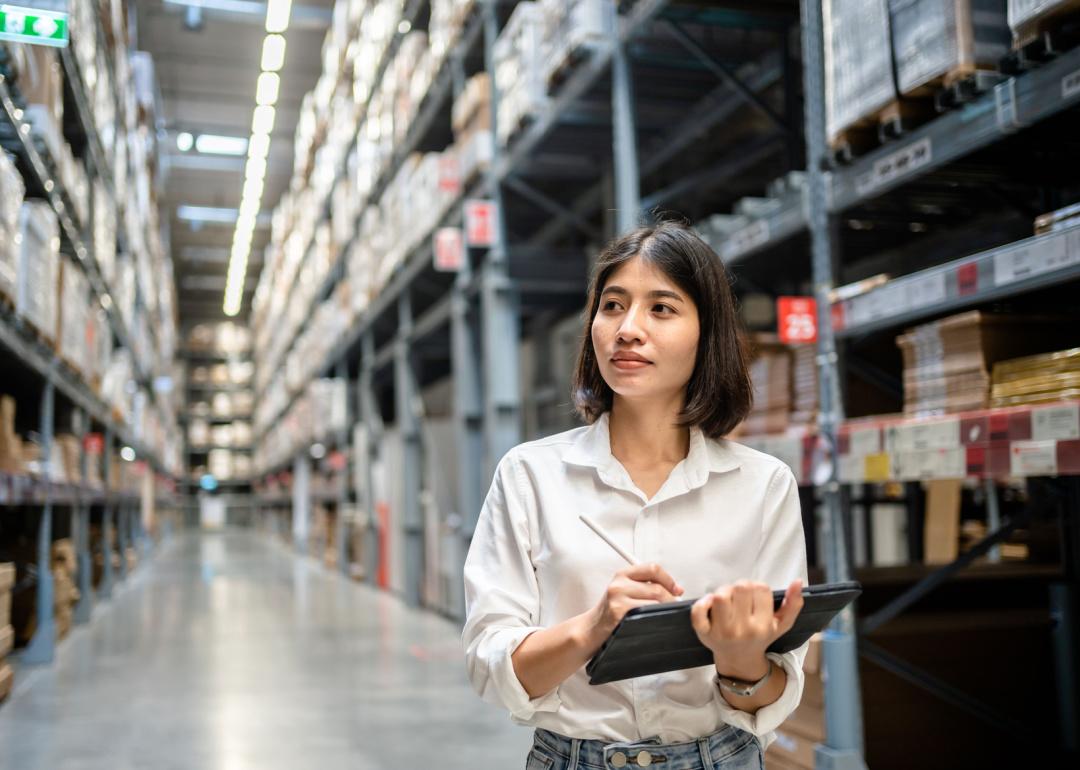 Woman working in warehouse with tablet.