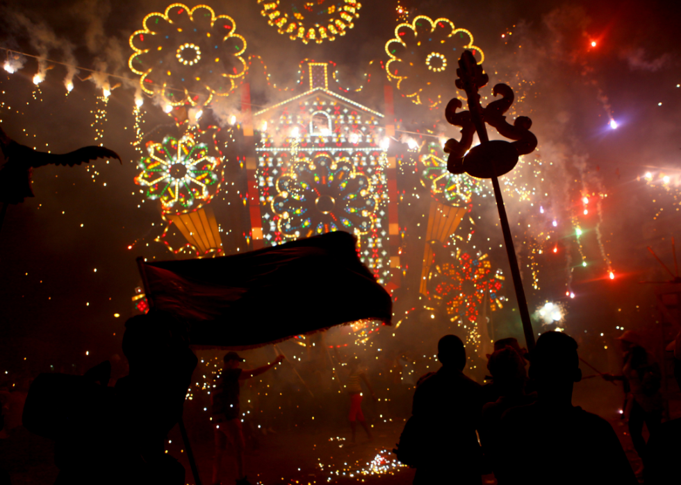 Hazy streets with bright lights and people celebrating.