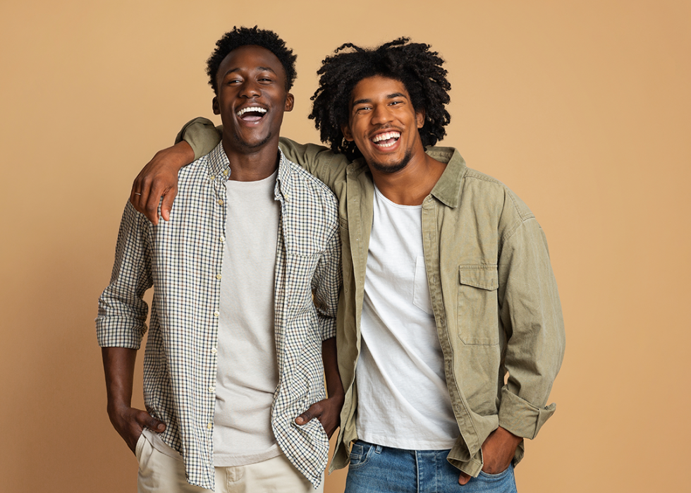 Two Black male friends embracing.