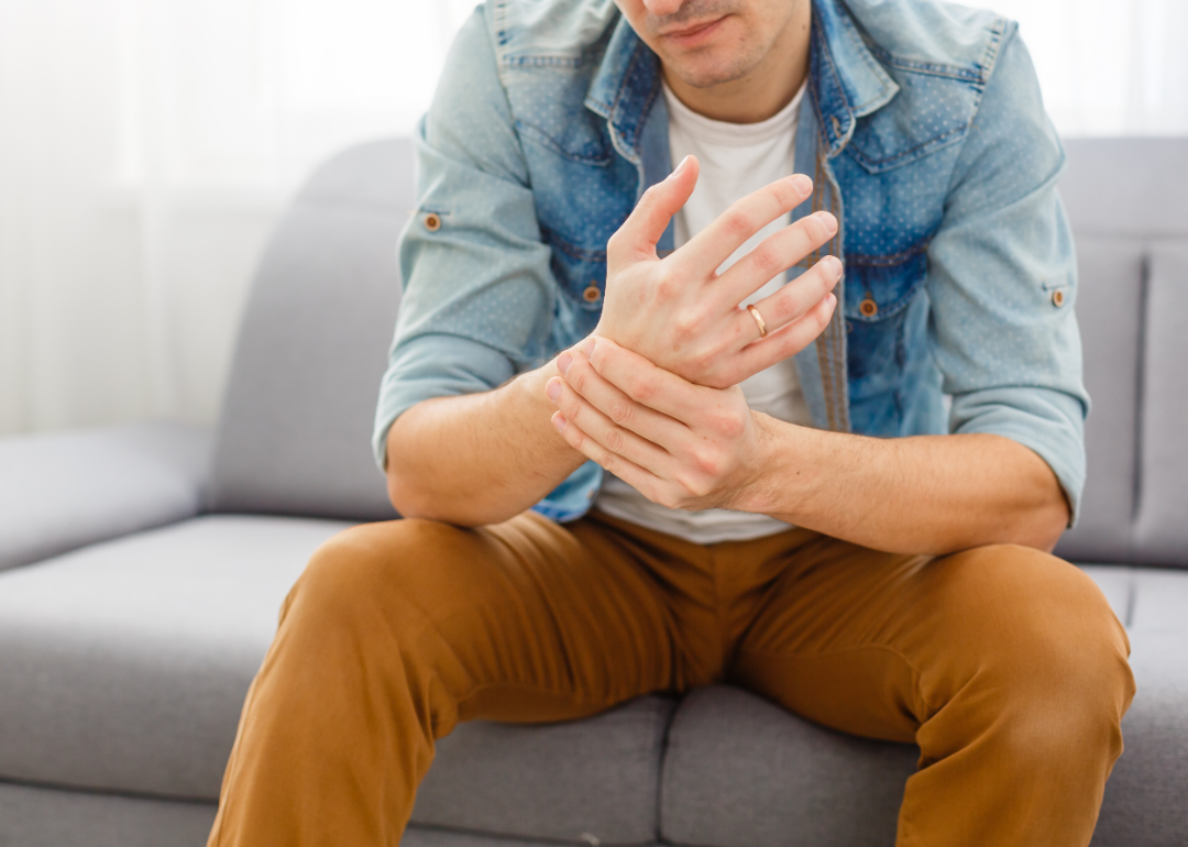 Man holding wrist.