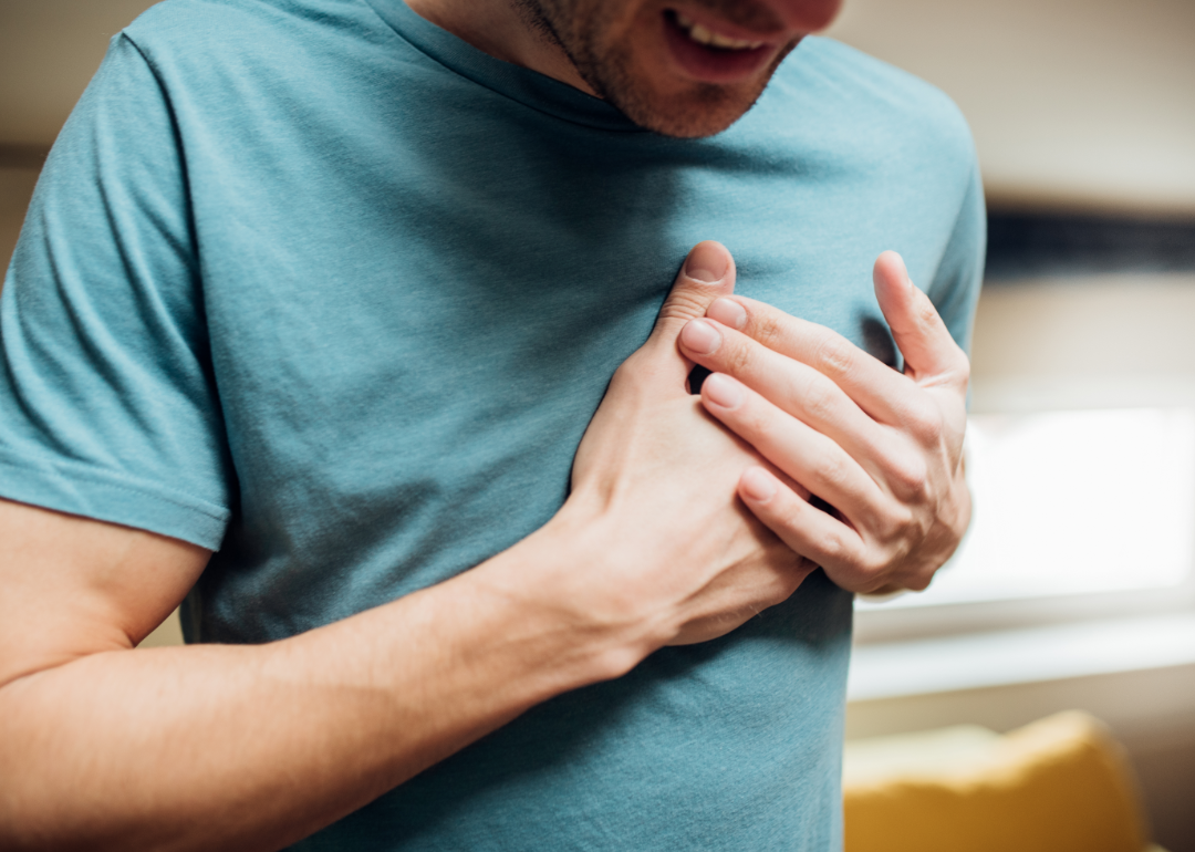 Cropped view of man holding chest.