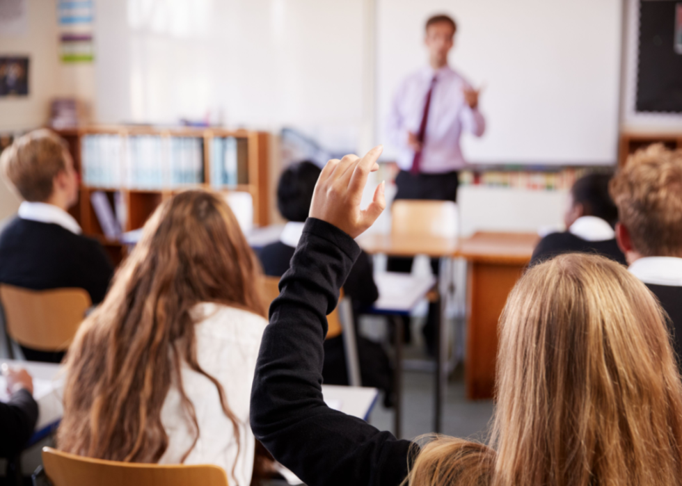 Female student raises hand in class